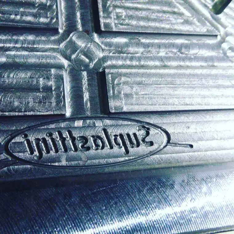 Detalhe de gravação de logotipo do cliente usinada na cavidade do molde